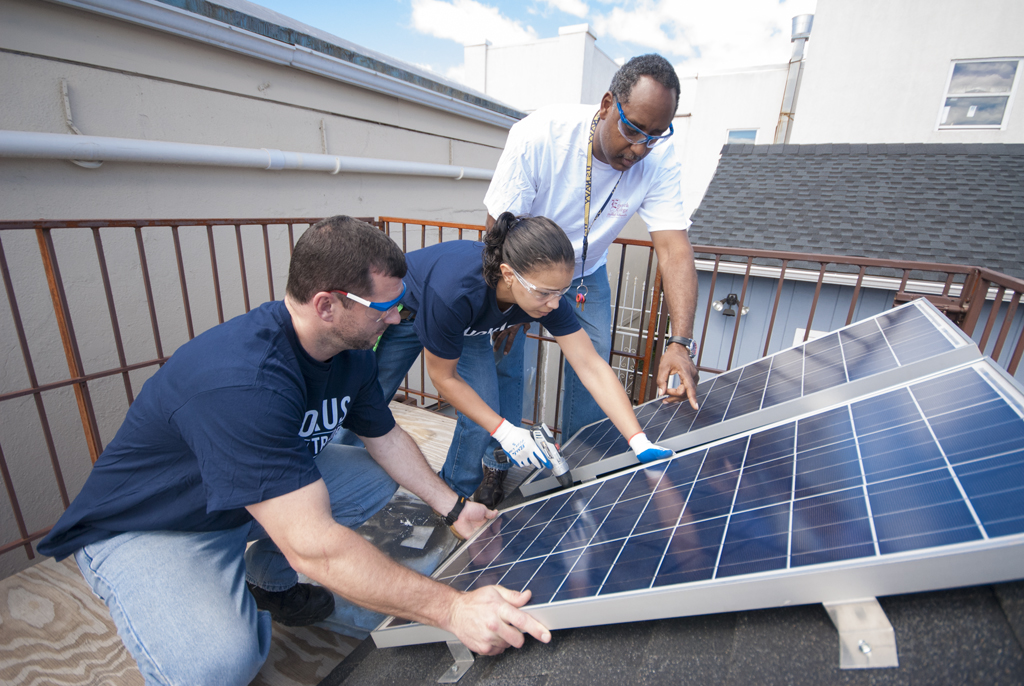 Construction training students set up solar panels