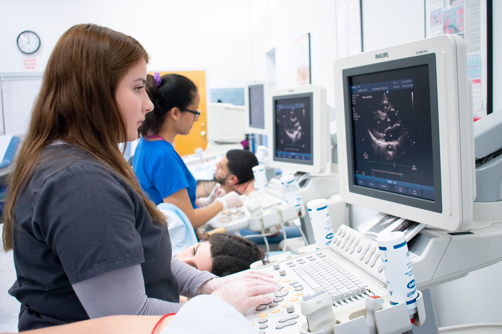 Sonography students practice using ultrasound machines