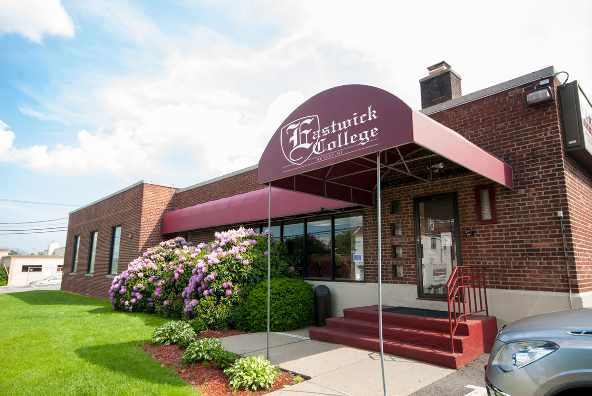 Front door of eastwick college in nutley with awning and flowers