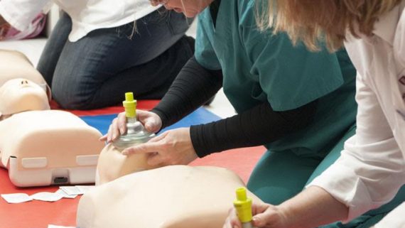 medical students practice using cpr breathing device