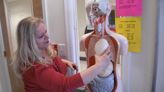nursing student practices anatomy on mannequin