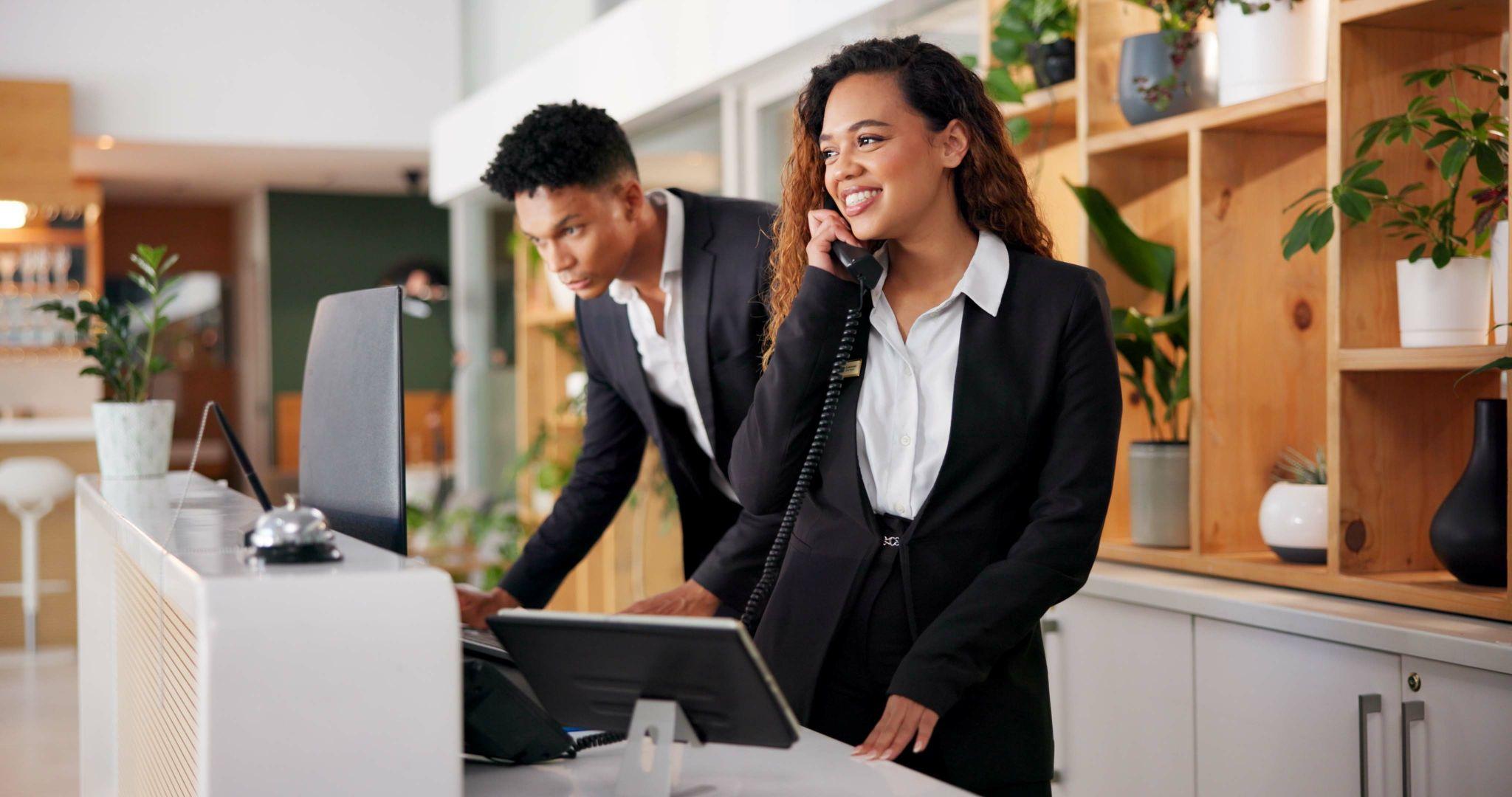 Students managing a mock front desk in Business and Hospitality lab setting